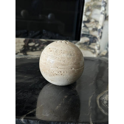Beige travertine marble sphere incense burner in natural stone with round minimalist design for luxury home decor and aromatherapy on a desk