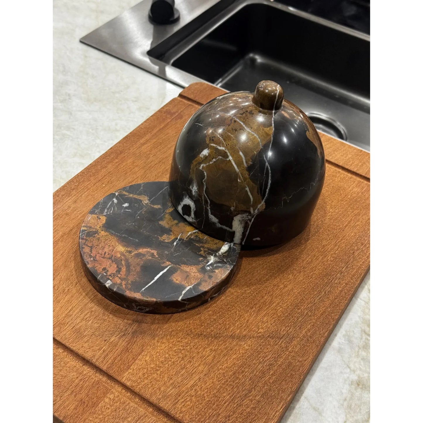 Marble butter dish with lid on chopping board close up