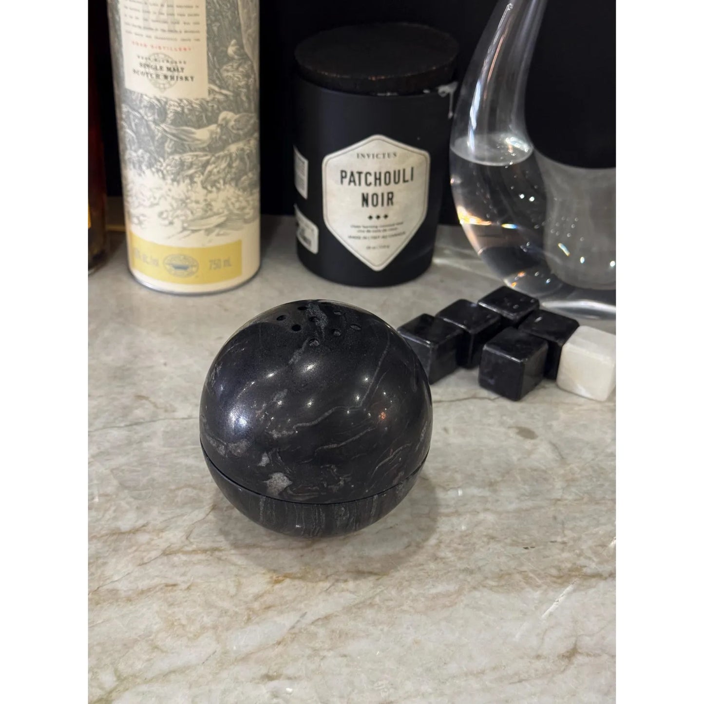 Titanium black marble sphere incense burner with natural stone texture on desk