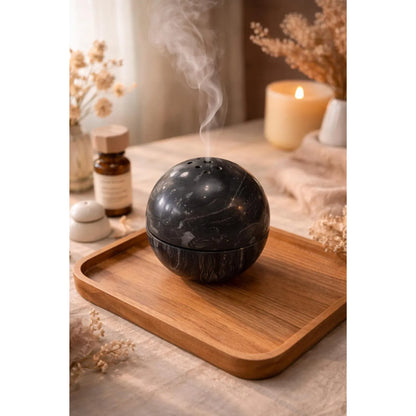 Titanium black marble sphere incense burner with natural stone texture with incense burning smoke