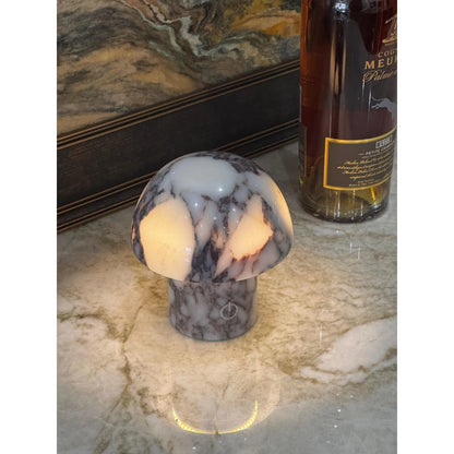 calacatta viola marble mushroom lamp with purple veining on desk glowing luxury setting